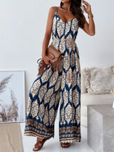 Woman wearing a blue and beige patterned jumpsuit in a living room setting.
