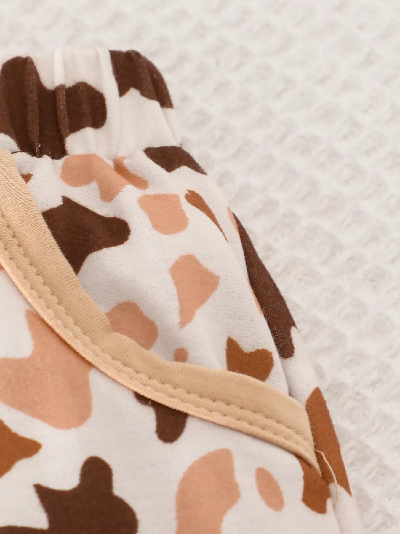 Children's two-piece farm animal outfit featuring a beige long-sleeve sweatshirt with embroidered cows and coordinating brown and cream cow-print drawstring pants.