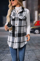 Woman wearing a gray plaid button-up vest coat layered over a white turtleneck with blue jeans and gold jewelry for a cozy fall outfit.