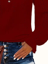 Red long-sleeve top worn by a person with a white background
