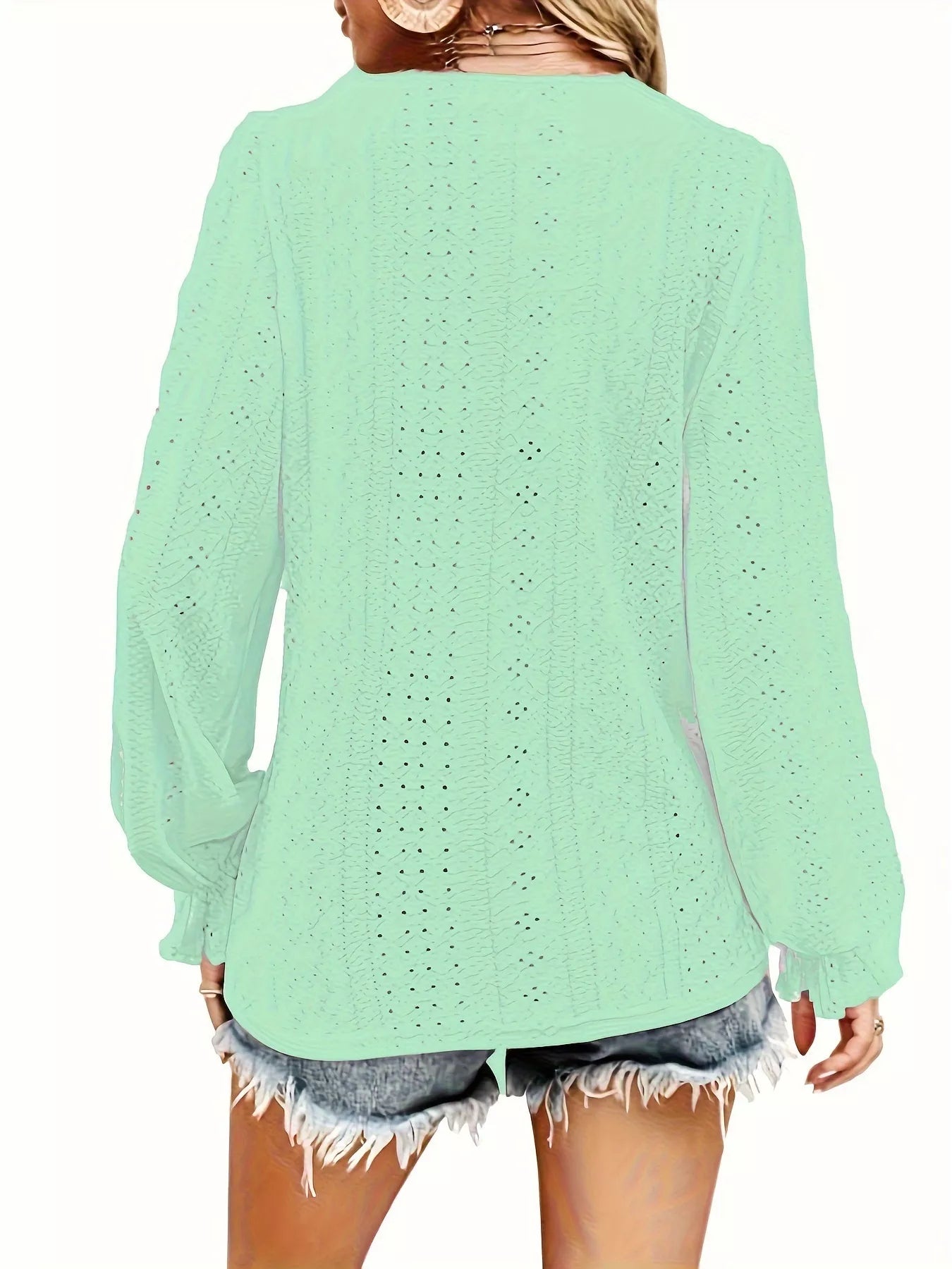 Light green blouse worn by a person on a white background showing the back of blouse