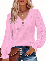 Woman wearing a pink blouse with long sleeves and a V-neckline on a white background