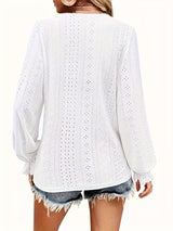 White lace top worn by a person on a white background showing back of blouse