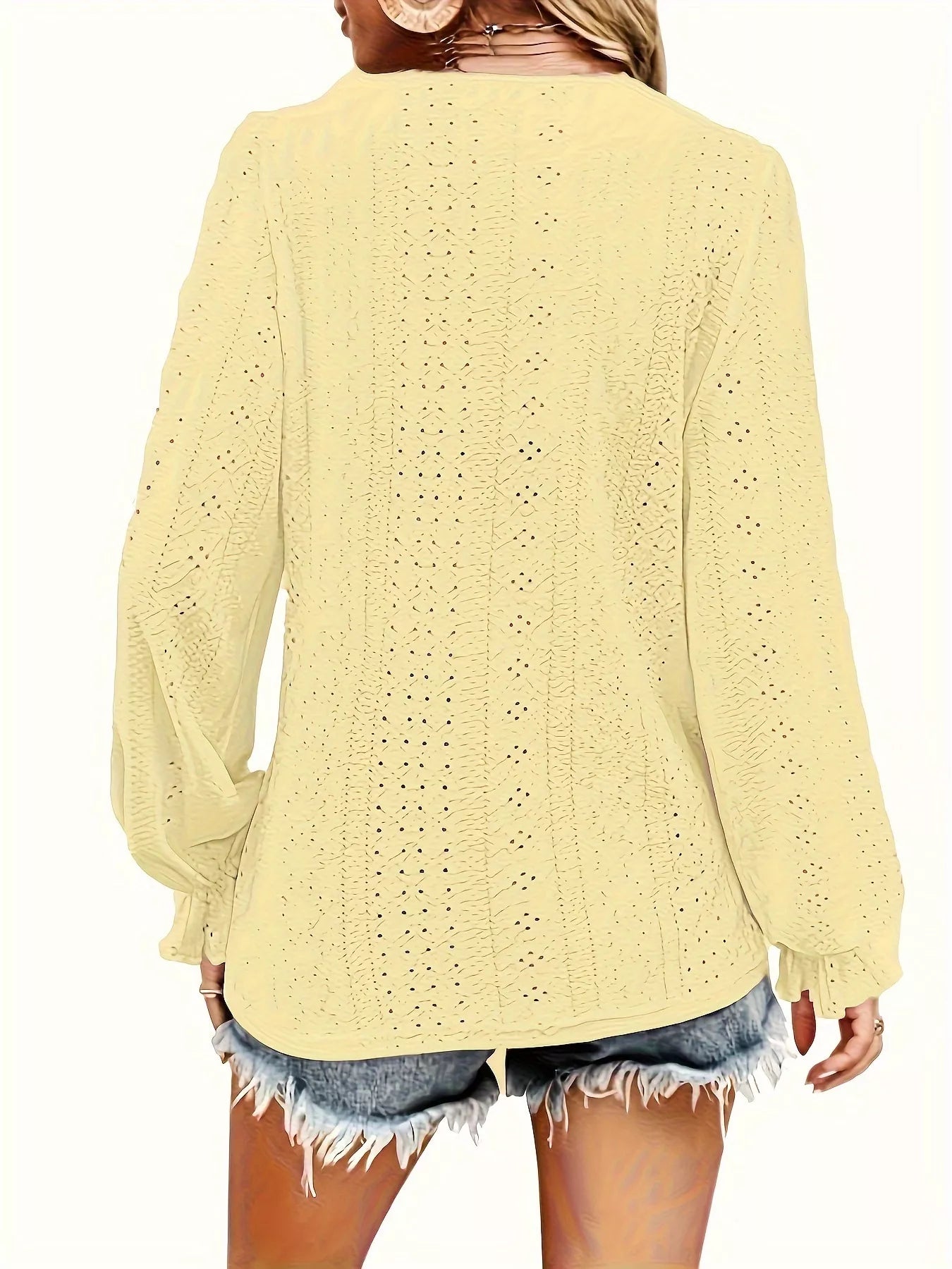 Light yellow blouse worn by a person on a white background showing back of blouse