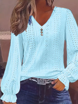 Light blue blouse with long sleeves and button details worn by a person.