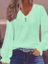 Light green blouse with a V-neck and long sleeves worn by a person.