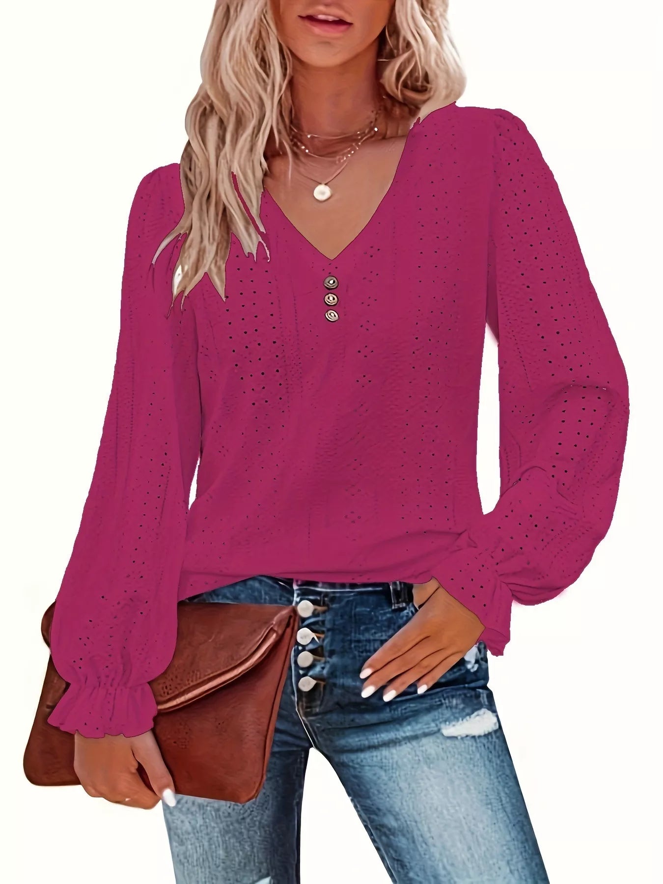 Woman wearing a rose red long-sleeve top with a brown purse on a white background