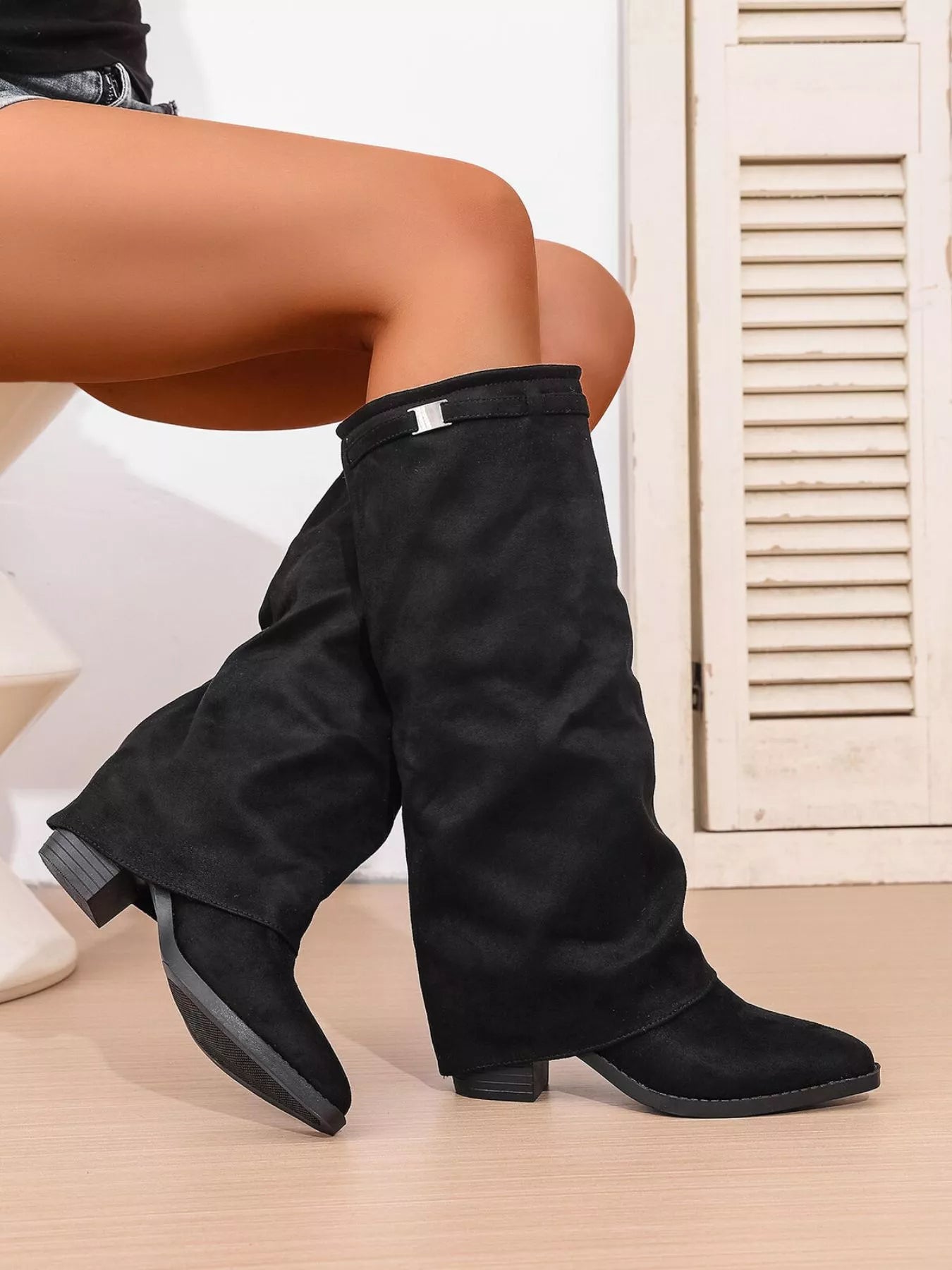 Woman wearing black point toe block heel boots featuring a classic Western-inspired silhouette with a comfortable low heel, perfect for pairing with fall dresses, denim, and cozy sweaters.
