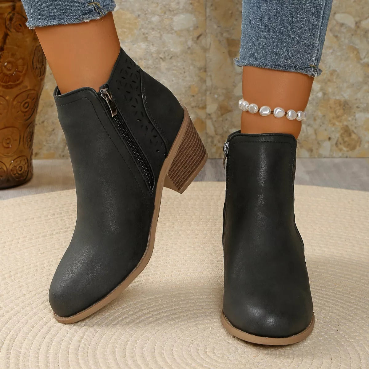 Women’s point toe block heel ankle boots with perforated side detail in black.