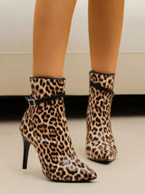 Leopard print ankle boots worn by a person on a neutral background