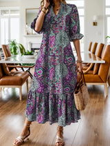 Woman wearing a purple bohemian paisley print midi dress with three-quarter sleeves and ruffled hem.