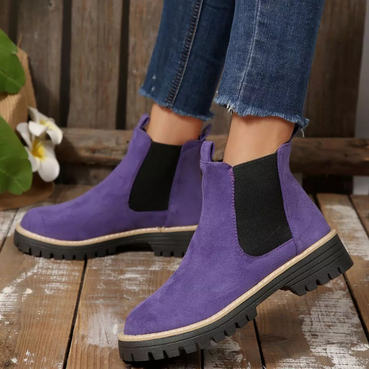 Purple suede round toe Chelsea ankle boots with black elastic side panels, mid-block heels and lug soles.