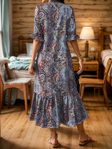 Woman wearing a red bohemian paisley print midi dress with three-quarter sleeves and ruffled hem.