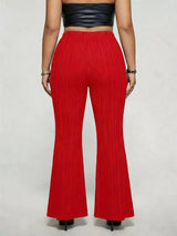 Model wearing red plus-size high-waisted flare pants styled with pointed-toe heels for an elegant and sophisticated look.