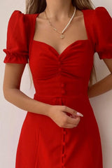 Woman wearing a red sweetheart-neck midi dress with puff sleeves, ruched detailing, and a button-front slit.