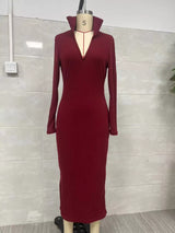 Woman wearing a burgundy ribbed knit V-neck long sleeve sweater dress styled with a black belt and tall brown Western boots.