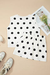 White sleeveless top with black polka dots and matching shorts on a beige background.