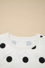 Close-up of a white shirt with black polka dots on a beige background