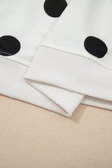 Close-up of a white fabric with black polka dots on a beige surface