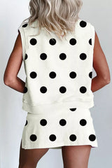 Person wearing a polka dot sleeveless top and skirt set on a plain background