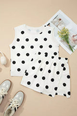 White tank top with black polka dots on a beige surface with sneakers and a magazine.
