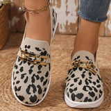 Leopard print loafers with gold accents worn by a person on a woven surface.