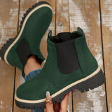 Green suede round toe Chelsea ankle boots with black elastic side panels, mid-block heels and lug soles.
