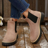 Beige suede round toe Chelsea ankle boots with black elastic side panels, mid-block heels and lug soles.