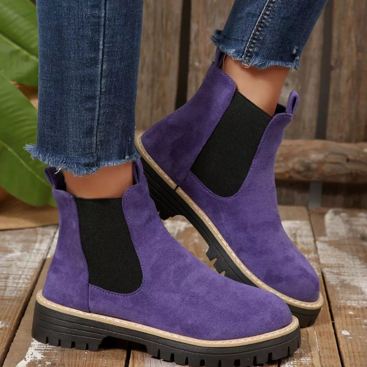 Purple suede round toe Chelsea ankle boots with black elastic side panels, mid-block heels and lug soles.