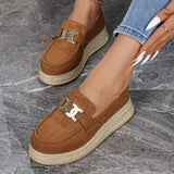 Brown suede loafers with gold buckles on a gray marble surface
