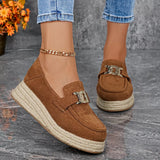 Brown suede loafers with espadrille sole worn by a person on a gray surface.