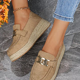 Beige espadrille loafers with chain detail on a stone floor.