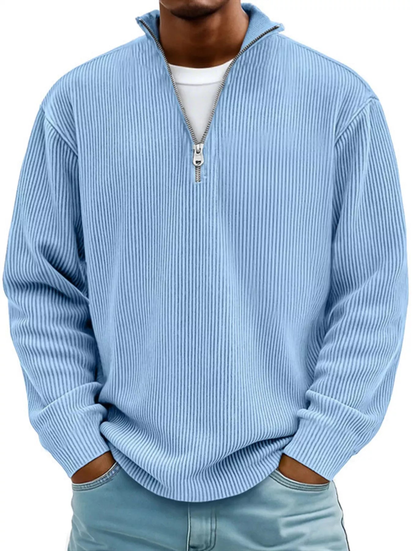 Man wearing a sky-blue ribbed corduroy quarter zip pullover sweatshirt layered over a white shirt.