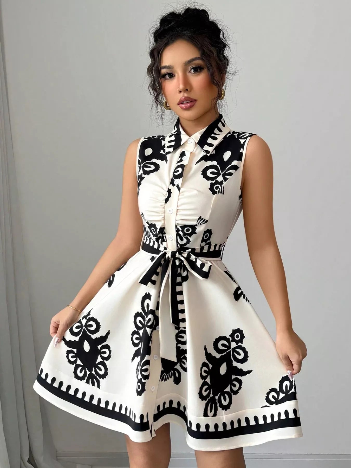 Woman wearing a white dress with black pattern against a gray background