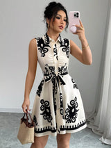 Woman taking a mirror selfie wearing a black and white patterned dress.