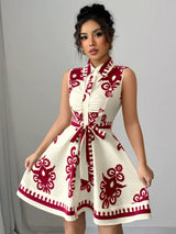 Woman wearing a white dress with red patterns against a gray background
