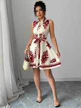 Woman wearing a white dress with red patterns in an indoor setting