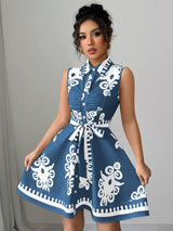 Woman wearing a blue dress with white patterns against a gray background