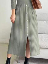 Woman wearing a green mock neck long sleeve knit midi dress with pleated skirt, front buttons and slit.