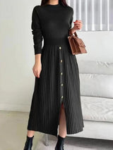 Woman wearing a black mock neck long sleeve knit midi dress with pleated skirt, front buttons and slit.