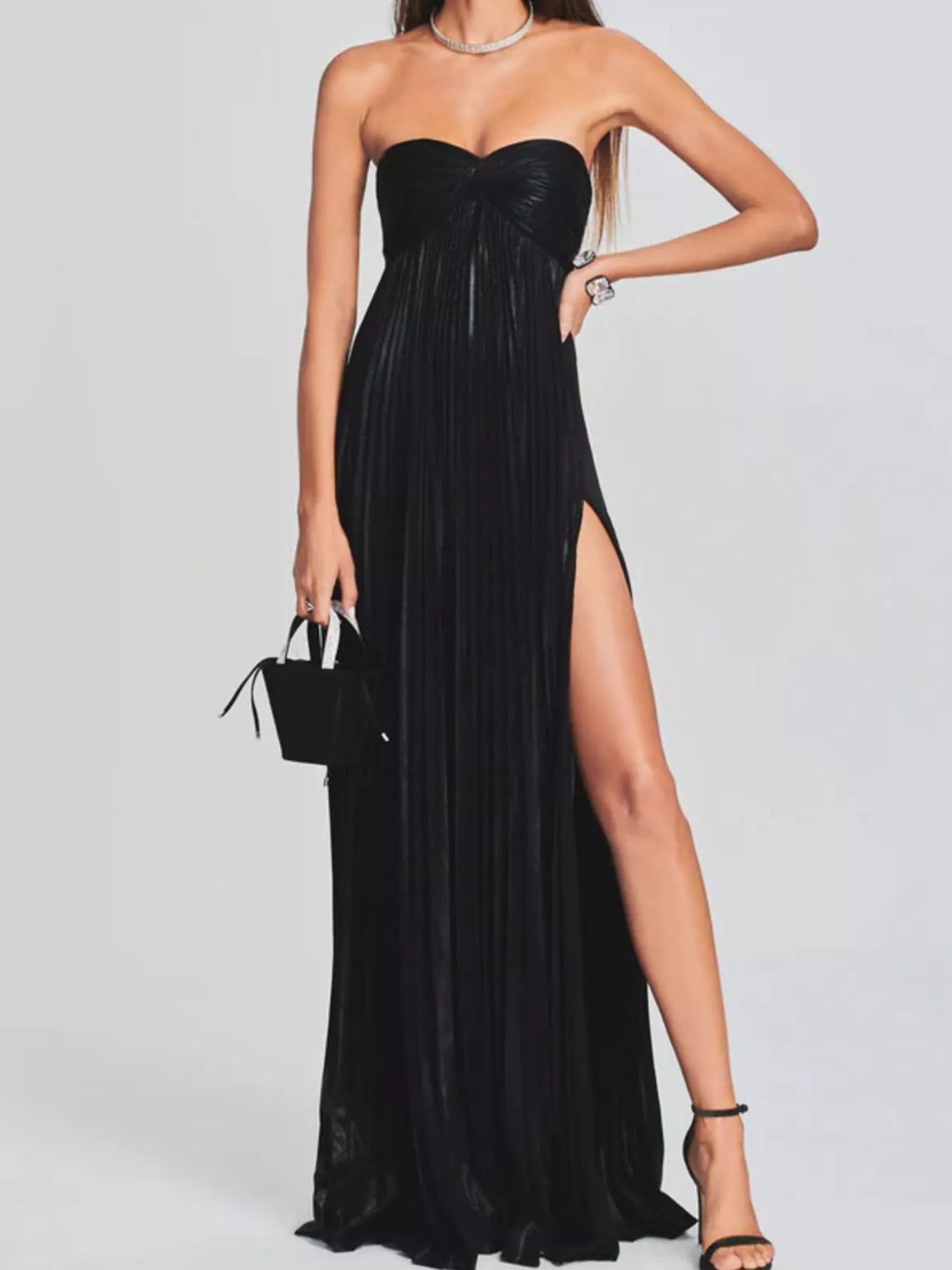 Black strapless gown with a high slit on a white background