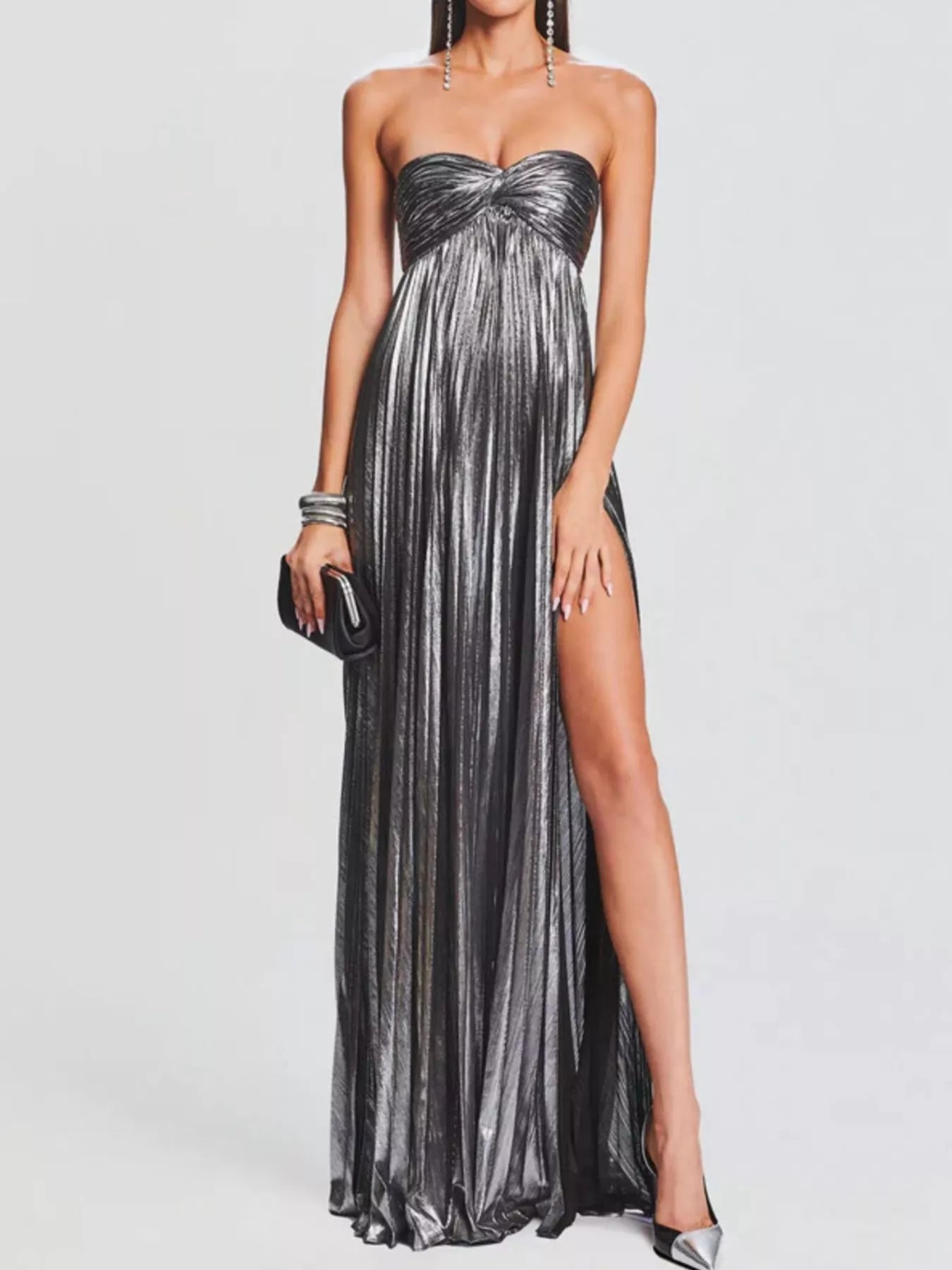 Woman wearing a strapless gray gown with a high slit on a white background