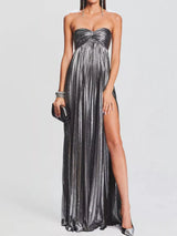 Woman wearing a strapless gray gown with a high slit on a white background