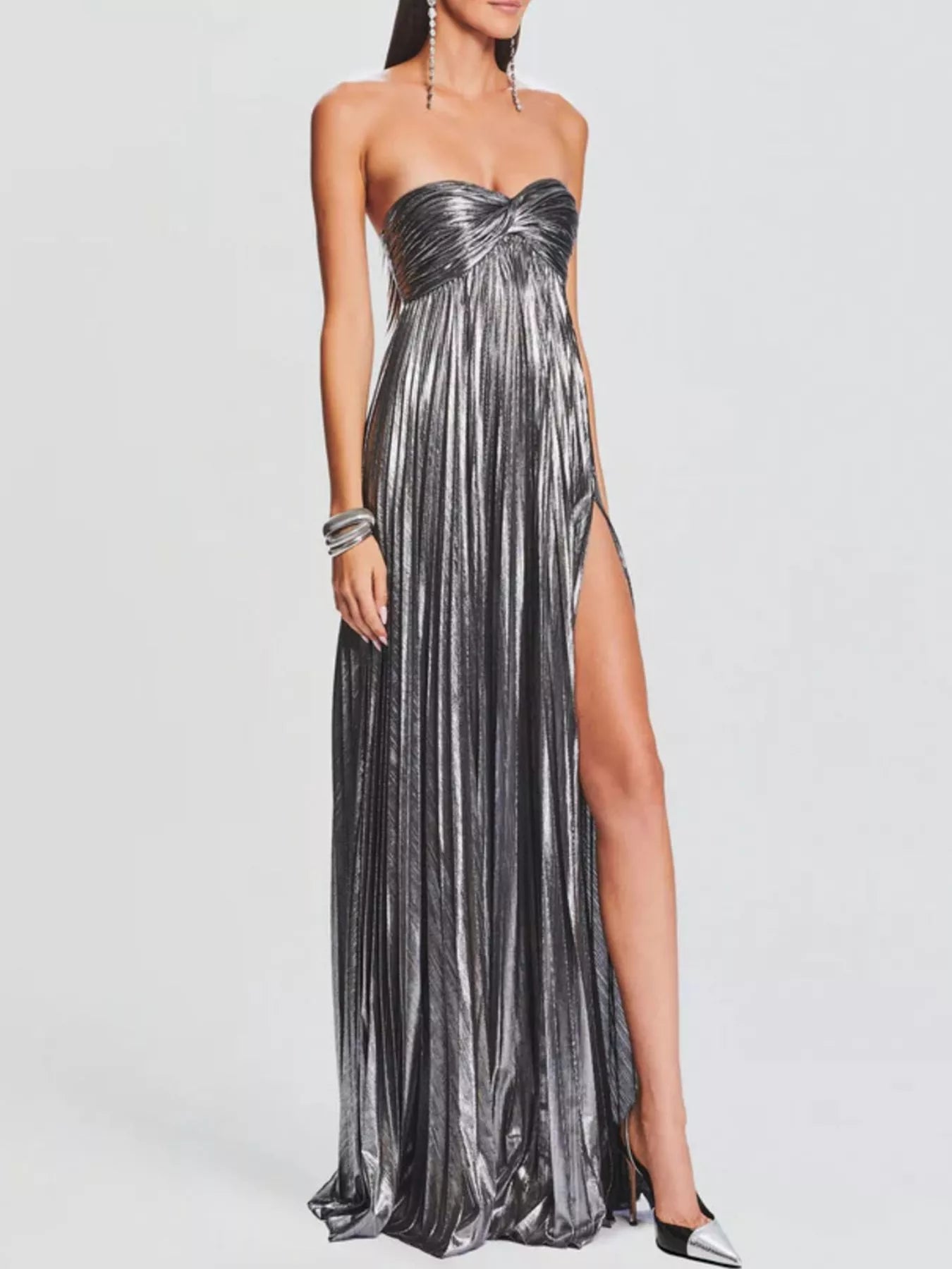 Woman wearing a gray strapless gown with a high slit on a white background