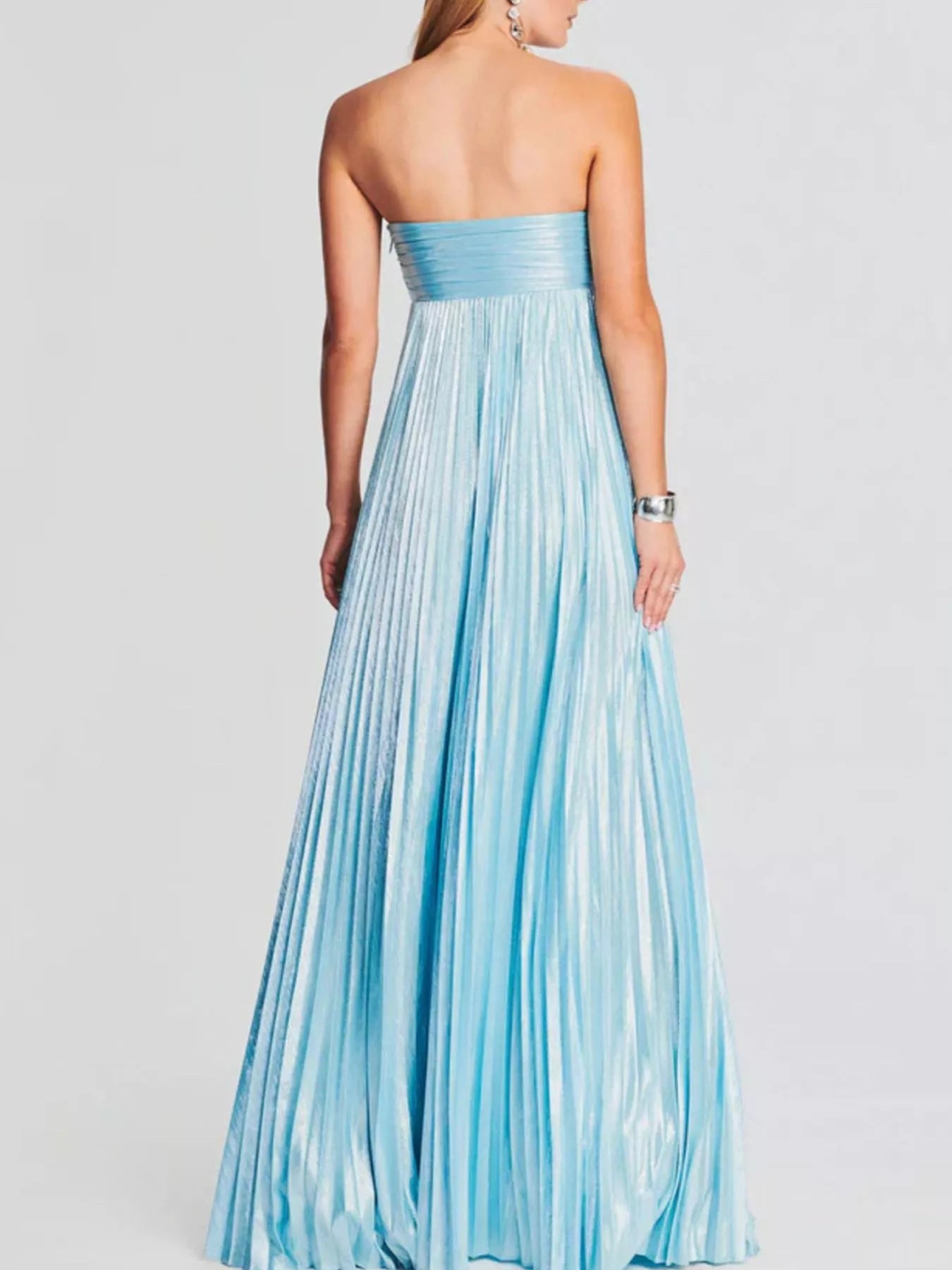 Woman wearing a light blue strapless gown on a white background