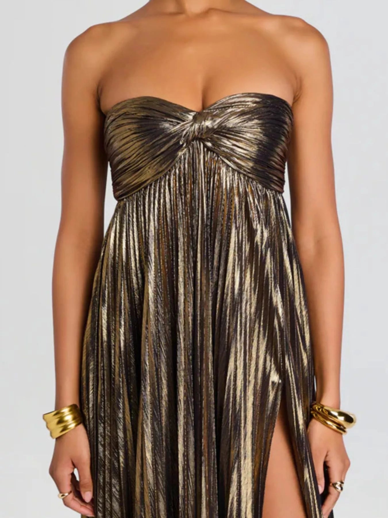 Khaki strapless gown with a slit on a plain background