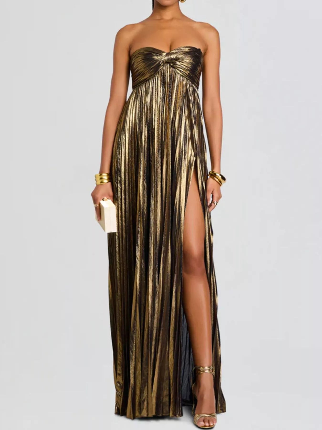 Gold strapless gown with a high slit on a white background
