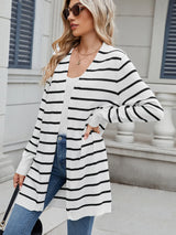 Woman wearing a black and white striped open front cardigan with blue jeans, layered over a white tank top for a casual everyday outfit.