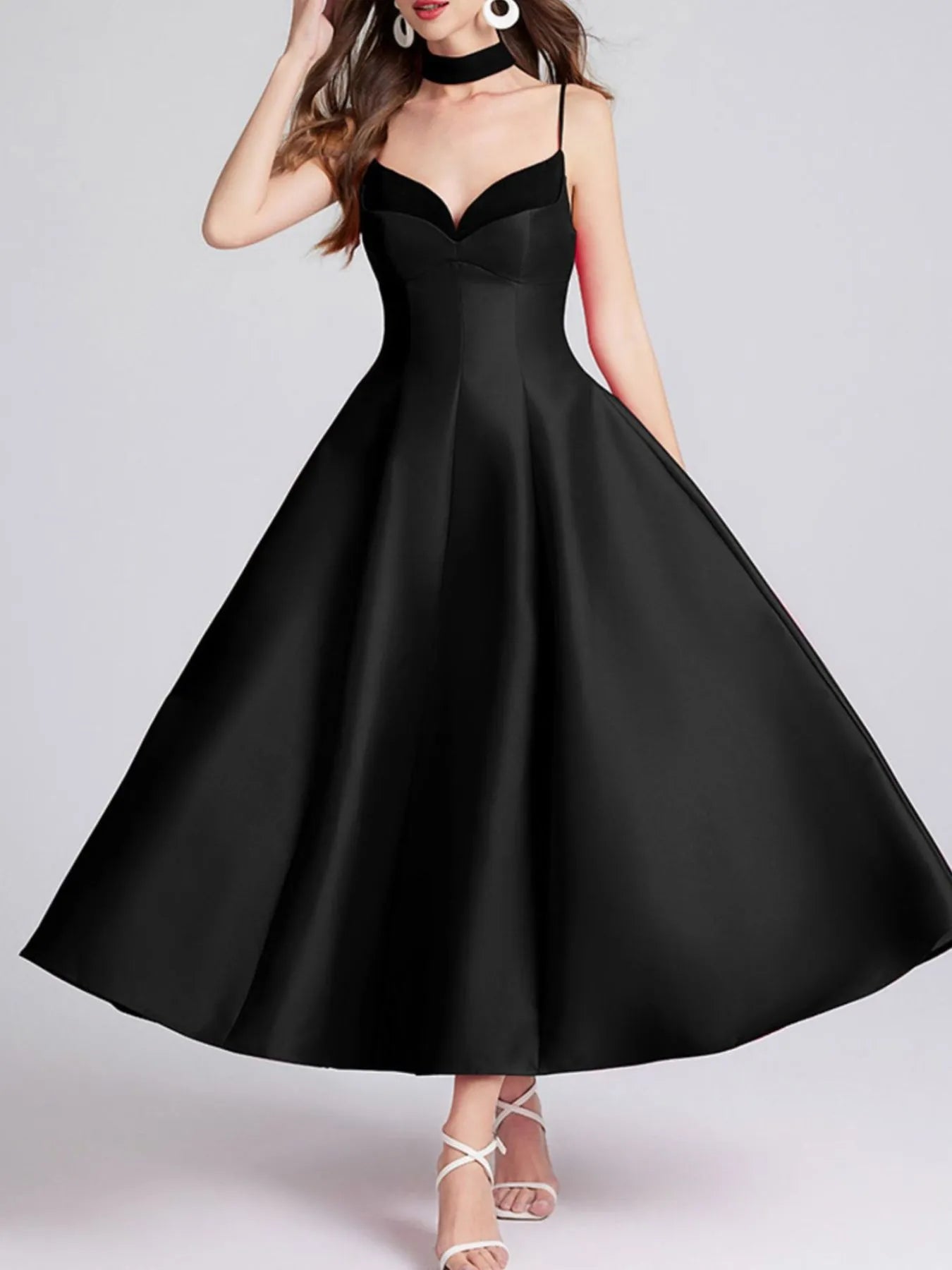 Black dress worn by a model on a gray background