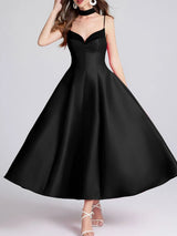 Black dress worn by a model on a gray background